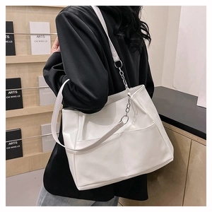 Dettaglio borsa tote in pelle PU bianca con catena argentata portata a spalla