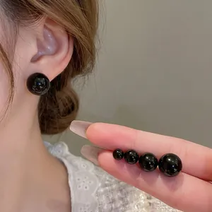 Minimalist black round stud earrings in four sizes with premium mirror finish texture