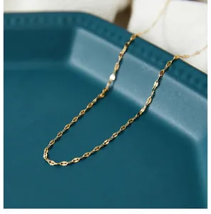 Detailed view of a gold-plated stainless steel lip chain on a blue ceramic tray
