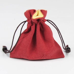 Dettaglio del sacchetto per gioielli in velluto rosso con fodera gialla e coulisse