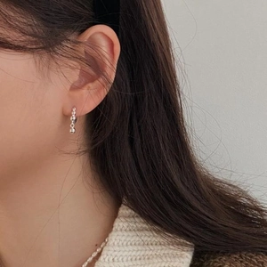 Close-up of minimalist 925 silver beaded earrings with small sphere drop pendant