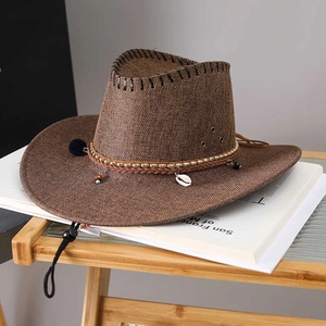 Detail of a brown woven cowboy hat with leather band, metallic beads, and shells