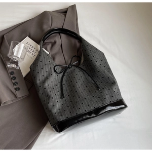 Close-up of black heart pattern fabric on a stylish bucket bag with leather accents