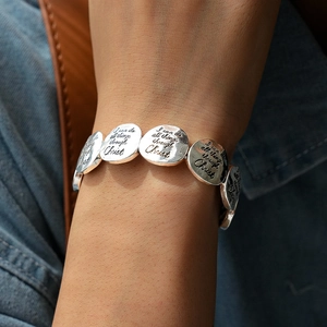 Détail du bracelet argenté gravé I can do all things through Christ porté au poignet