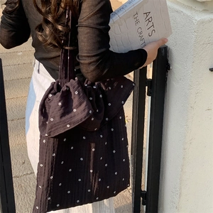 Close-up of floral chiffon tote bag with white flower patterns and bow-tie ruffle strap detail
