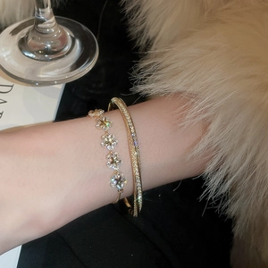 Detailed view of gold-plated star and flower bracelets with sparkling zircon stones