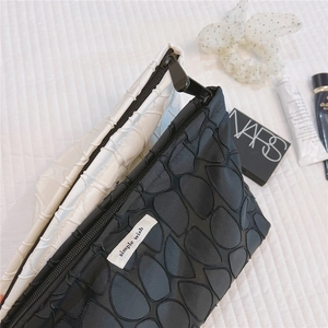 Detail shot of bubble textured canvas makeup bags in black and white with zipper closure
