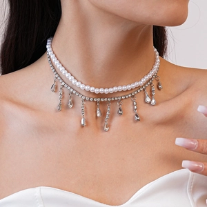 Close-up of double-layered pearl necklace with sparkling teardrop zircon pendants
