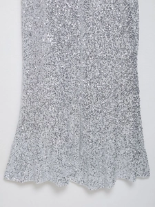 Détail du tissu à paillettes argentées montrant la texture brillante et la qualité du tissu