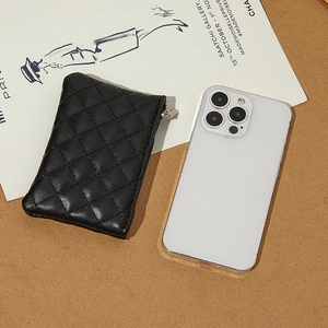 Quilted black PU leather coin purse with silver zipper next to a smartphone