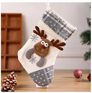 Detail of grey and white Christmas stocking with embroidered reindeer and snowflake patterns