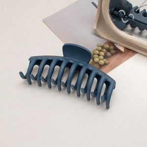 Detailed view of large matte navy blue hair claw clip on a stylish decorative background