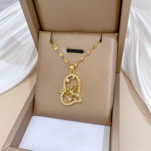 Luxurious gold butterfly heart necklace with crystals on white silk background