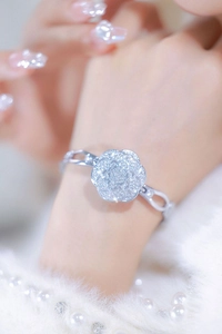 Detail of a silver camellia flower bracelet watch featuring sparkling gemstone inlay