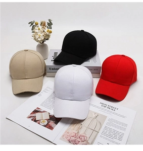 Diverse berretti da baseball in tela nei colori nero, bianco, rosso e kaki su base minimale