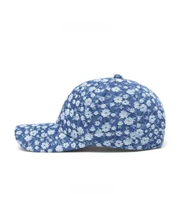 Side view detail of denim baseball cap featuring white floral pattern and six-panel design