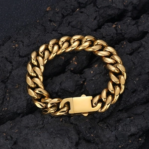 Chunky gold stainless steel Cuban link bracelet for men on black textured rock background