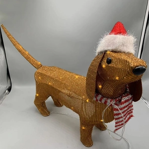 Macro shot of LED dachshund outdoor light with red scarf and warm glowing mesh detail