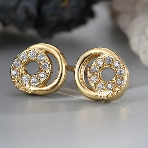 Macro shot of gold-plated circular earrings with sparkling cubic zirconia inlay