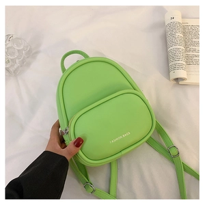 Close-up of a mini green PU leather backpack with silver text and smooth texture