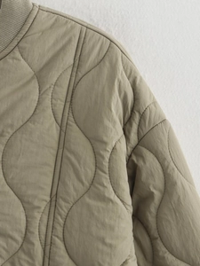 Detail of wavy quilted texture and ribbed collar on khaki fashion jacket for women