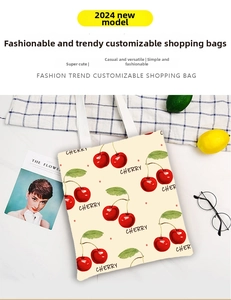 Detailed top view of a white canvas tote bag with cherry prints on marble surface