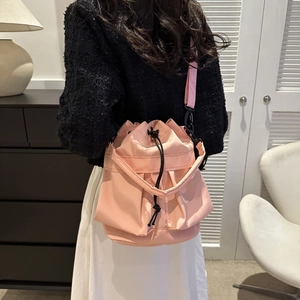 Vue arrière d'un mannequin portant un sac seau rose en nylon avec cordon de serrage