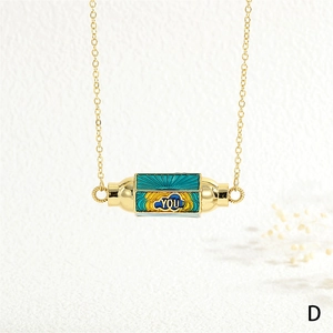 Detail of gold chain necklace with enamel hexagonal cylinder pendant featuring YOU text