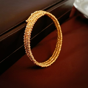 Vue détaillée du bracelet multi-rangs doré avec texture perlée fine et embouts polis