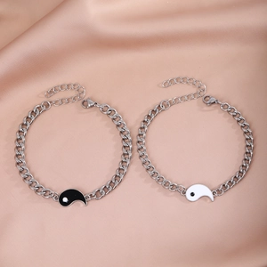 Close-up of Yin Yang Tai Chi pendants on adjustable stainless steel couple bracelets