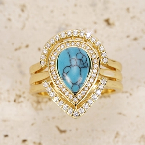 Macro detail of Bohemian teardrop ring with turquoise stone and golden metal finish