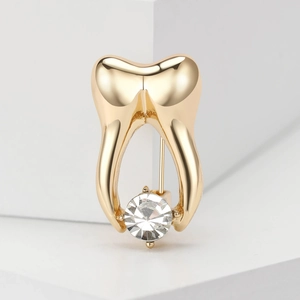 Detailed view of a vintage gold alloy tooth brooch with a sparkling zircon inlay