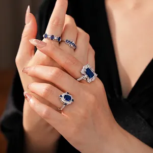 Luxe set of four silver zircon rings with deep blue sapphire-colored stones on hand