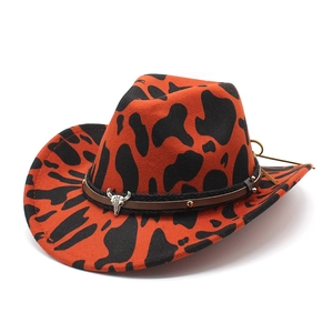 Detail of western orange cow print fedora with studded leather band and silver steer skull