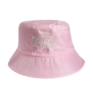 Close-up of pink cotton bucket hat featuring white vintage embroidery and neat stitching