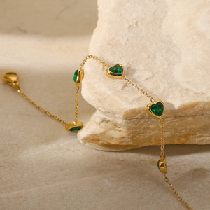 Vue détaillée du zircon vert en forme de cœur sur une fine chaîne en titane plaqué or 14K