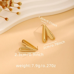 Macro shot of gold V-shaped heart earrings showing size dimensions and metal weight detail