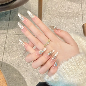 Sparkly handmade press-on nails with champagne gold gradient and emerald gemstones