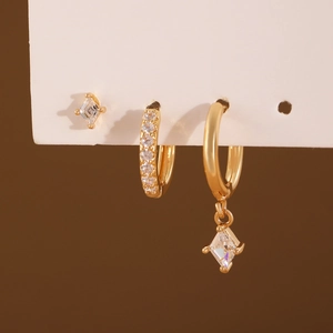 Three-piece gold earring set with rhombus pendants and clear zircon stones on a card