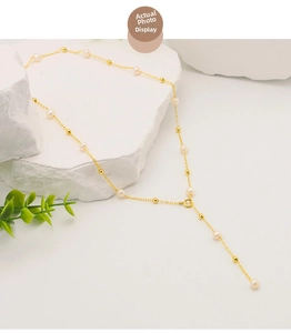 Detailed close-up of a Y-shaped gold necklace with natural freshwater pearls and beads