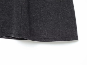Detailed close-up of dark grey soft wool-like fabric texture and fine hem stitching