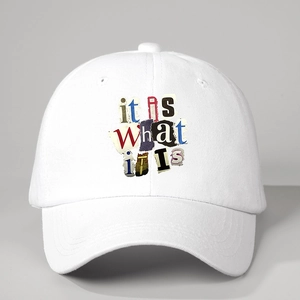 Detail of white cotton baseball cap showing it IS WHAT iS collage print and 6-panel crown