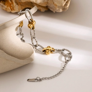 Detail of 18k gold and silver two-tone stainless steel chain with hammered texture links
