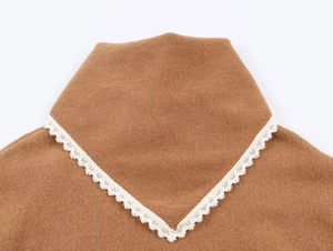 Vue détaillée du col en V avec bordure en dentelle blanche sur un pull en maille camel