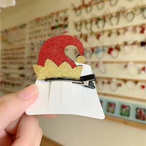 Close-up of sequined Christmas elf hat hair clip on a display card for holiday hair styling