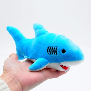 Close-up of a mini blue shark plush toy held in hand showing its small portable size
