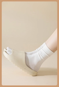 Detail of cream foam slide sandals worn with white combed cotton mid-calf socks