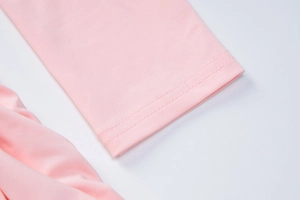 Gros plan détaillé sur la manche rose présentant des finitions soignées à double couture