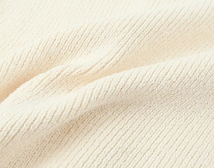 Vue macro d'un tricot crème avec texture détaillée des fibres et motifs côtelés