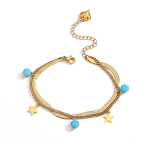 Detail of gold double-layer bracelet with blue beads, star and heart charms on white base